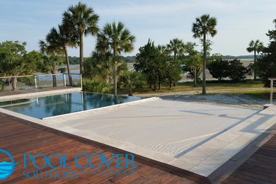 Pool - large contemporary backyard rectangular infinity pool idea in Charleston with decking