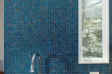 Inspiration for a mid-sized contemporary l-shaped medium tone wood floor kitchen remodel in San Francisco with an undermount sink, flat-panel cabinets, light wood cabinets, quartz countertops, blue backsplash, mosaic tile backsplash, stainless steel appliances and no island