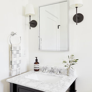 Ejemplo de cuarto de baño con ducha, mediterráneo, de tamaño medio, con armarios tipo mueble, puertas de armario negras, ducha empotrada, sanitario de dos piezas, baldosas y/o azulejos blancos, baldosas y/o azulejos de cerámica, paredes blancas, suelo de azulejos de cemento, lavabo bajoencimera, encimera de mármol, suelo blanco, ducha con puerta con bisagras y encimeras blancas