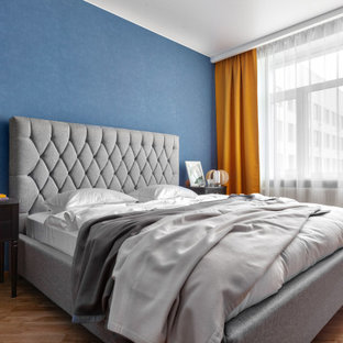 На фото: хозяйские спальни среднего размера в современном стиле с синими стенами, паркетным полом среднего тона и бежевым полом