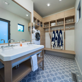 ソルトレイクシティのトランジショナルスタイルのおしゃれな家事室 (上下配置の洗濯機・乾燥機、青い床、ドロップインシンク) の写真