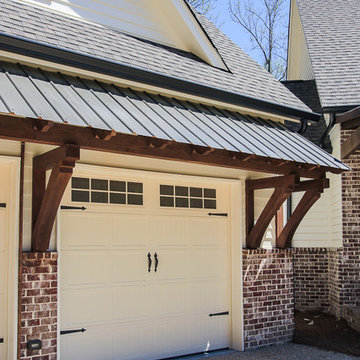 Metal shed roof over garage doors with wood brackets
