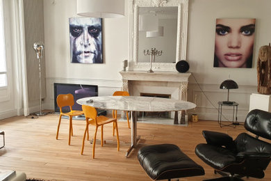 Réalisation d'un grand salon design ouvert avec parquet clair, une cheminée standard et un manteau de cheminée en pierre de parement.