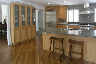 Eat-in kitchen - large transitional galley medium tone wood floor eat-in kitchen idea in New York with a double-bowl sink, shaker cabinets, light wood cabinets, gray backsplash, stainless steel appliances, a peninsula and concrete countertops