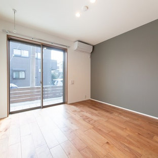 Ispirazione per una camera matrimoniale etnica con pareti grigie, pavimento in compensato, nessun camino e pavimento marrone