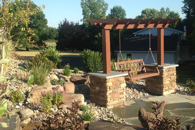 Design ideas for a large southwestern drought-tolerant and full sun backyard stone retaining wall landscape in New York.
