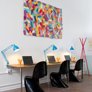 This is an example of a modern home office and library in Los Angeles with concrete flooring and white walls.