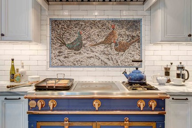 Mid-sized transitional u-shaped slate floor and gray floor eat-in kitchen photo in New York with a farmhouse sink, recessed-panel cabinets, white cabinets, marble countertops, white backsplash, brick backsplash, paneled appliances and a peninsula