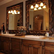 Dark brown cabinets, square sinks, lights on mirrors