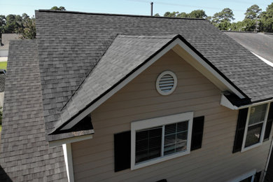 Imagen de fachada de casa pareada negra tradicional de dos plantas con tejado a dos aguas y tejado de teja de madera