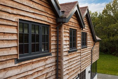 Inspiration for a classic house exterior in Hampshire with wood cladding and shiplap cladding.