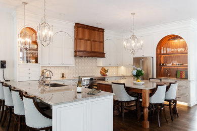 Inspiration for a mid-sized mediterranean u-shaped dark wood floor and brown floor eat-in kitchen remodel in Cedar Rapids with an undermount sink, flat-panel cabinets, white cabinets, marble countertops, beige backsplash, stainless steel appliances, beige countertops and cement tile backsplash