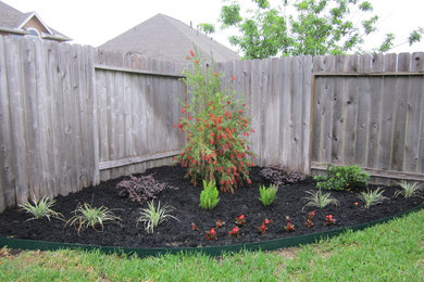 Design ideas for a mid-sized traditional full sun backyard landscaping in Houston.