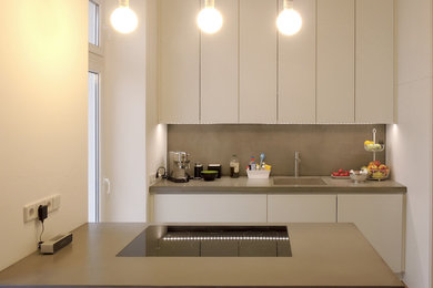 Diseño de cocina moderna abierta con armarios con paneles lisos, puertas de armario verdes, encimera de cemento y dos o más islas