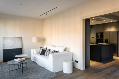 Imagen de salón para visitas abierto moderno grande con paredes beige, suelo laminado y suelo marrón