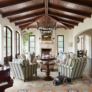 Foto de salón con rincón musical mediterráneo con paredes blancas, suelo de madera oscura y chimenea tradicional