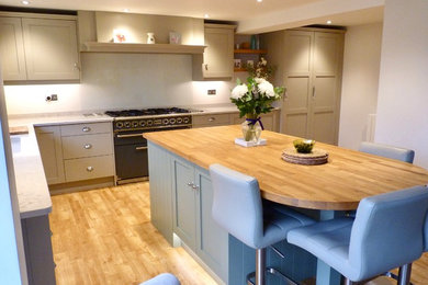 Design ideas for a large contemporary l-shaped open plan kitchen in Wiltshire with a built-in sink, shaker cabinets, beige cabinets, marble worktops, multi-coloured splashback, marble splashback, integrated appliances, medium hardwood flooring and an island.