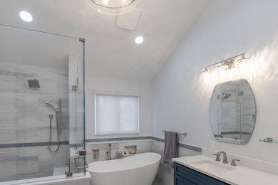 Bathroom - mid-sized transitional master gray tile and porcelain tile porcelain tile, gray floor and double-sink bathroom idea in Philadelphia with shaker cabinets, blue cabinets, a one-piece toilet, gray walls, an undermount sink, quartz countertops, a hinged shower door, white countertops, a niche and a built-in vanity