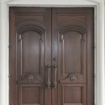 We are designers and builders of carved wood doors with wrought metal appliqués.