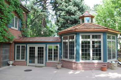 Large elegant red two-story brick house exterior photo in Denver with a shingle roof
