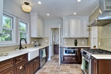 Mid-sized transitional u-shaped travertine floor enclosed kitchen photo in Detroit with a farmhouse sink, raised-panel cabinets, dark wood cabinets, granite countertops, gray backsplash, subway tile backsplash, stainless steel appliances and no island