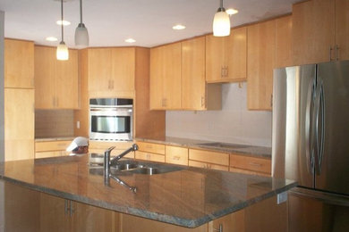Inspiration for a large l-shaped kitchen remodel in Phoenix with an undermount sink, flat-panel cabinets, light wood cabinets, granite countertops, stainless steel appliances and an island