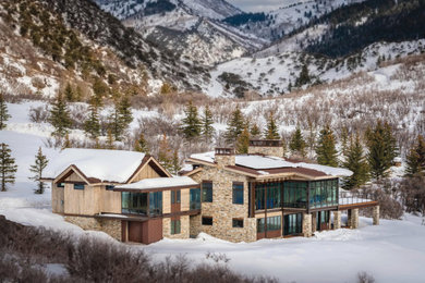 Example of a large trendy two-story wood house exterior design in Salt Lake City with a shed roof and a metal roof