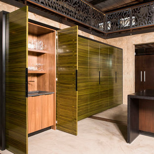 Large industrial kitchen pantry ideas - Kitchen pantry - large industrial galley concrete floor and beige floor kitchen pantry idea in Raleigh with an undermount sink, flat-panel cabinets, dark wood cabinets, granite countertops, paneled appliances and two islands