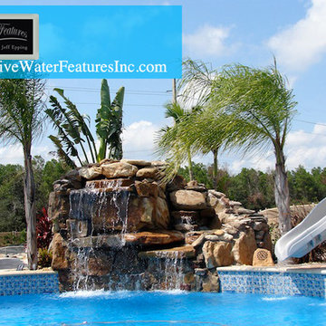 Tropical backyard room with pool waterfall, fireplace, and koi pond