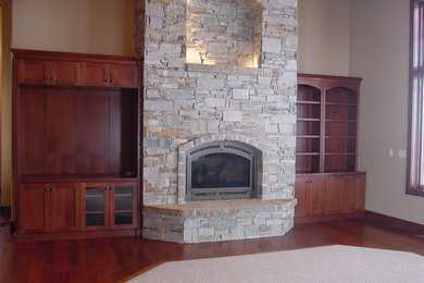 Imagen de salón abierto contemporáneo de tamaño medio con todas las chimeneas y marco de chimenea de piedra