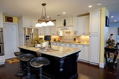 Inspiration for a farmhouse l-shaped vinyl floor open concept kitchen remodel in Jacksonville with raised-panel cabinets, white cabinets, granite countertops, beige backsplash, ceramic backsplash, stainless steel appliances and an island