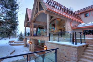 Example of a huge beige three-story stone gable roof design in Denver