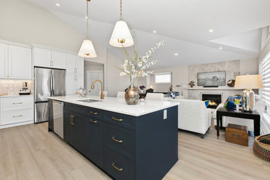 Inspiration for a mid-sized transitional single-wall vinyl floor, gray floor and vaulted ceiling open concept kitchen remodel in Edmonton with an undermount sink, recessed-panel cabinets, white cabinets, quartz countertops, beige backsplash, ceramic backsplash, colored appliances, an island and white countertops