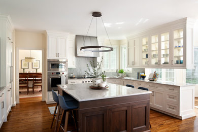 Open concept kitchen - mid-sized transitional u-shaped medium tone wood floor and brown floor open concept kitchen idea in DC Metro with an undermount sink, recessed-panel cabinets, dark wood cabinets, marble countertops, multicolored backsplash, marble backsplash, paneled appliances, an island and multicolored countertops