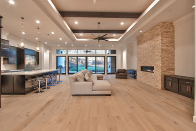 Family room - contemporary light wood floor family room idea in Sacramento with a brick fireplace