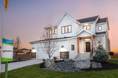 Inspiration for a large farmhouse white two-story concrete and board and batten exterior home remodel in Other with a shingle roof and a black roof