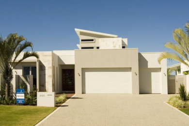 Photo of a large contemporary split-level beige house exterior in Brisbane with a shed roof.
