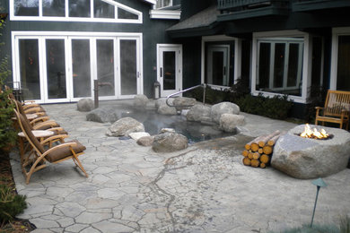 Design ideas for a mid-sized country backyard patio in Boise with a fire feature, natural stone pavers and no cover.