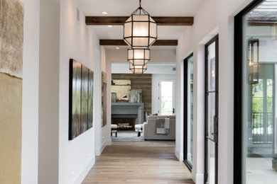 Inspiration for a light wood floor and white floor hallway remodel in Los Angeles with white walls