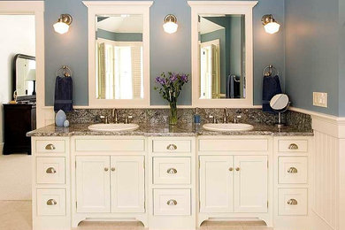 This is an example of a mid-sized contemporary master bathroom in Tampa with a drop-in sink, recessed-panel cabinets, white cabinets, granite benchtops, beige tile and blue walls.