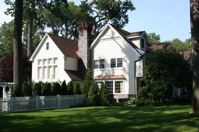 Large elegant white two-story wood exterior home photo in New York with a clipped gable roof