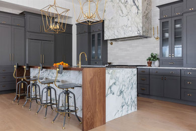 Example of a large transitional l-shaped light wood floor eat-in kitchen design in Phoenix with shaker cabinets, gray cabinets, marble countertops, white backsplash, stainless steel appliances, an island and white countertops