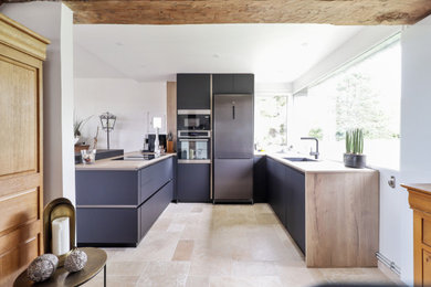 Exemple d'une petite cuisine ouverte noire et bois moderne en U avec un évier intégré, un placard à porte plane, des portes de placard noires, un plan de travail en stratifié, un électroménager en acier inoxydable, un sol en travertin, une péninsule, un sol beige et fenêtre au-dessus de l'évier.
