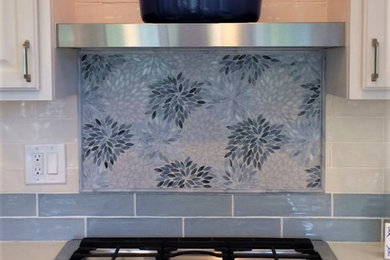 Large transitional porcelain tile and gray floor kitchen photo in Cleveland with an undermount sink, raised-panel cabinets, white cabinets, granite countertops, mosaic tile backsplash, stainless steel appliances and an island