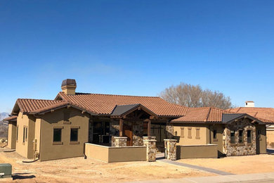 Rustic brown one-story stucco house exterior idea in Denver with a tile roof