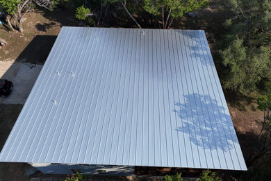Mid-sized minimalist two-story house exterior photo in Austin with a shed roof, a metal roof and a gray roof