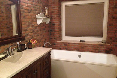 Example of a mid-sized mountain style master beige tile and travertine tile bathroom design in Edmonton with furniture-like cabinets, dark wood cabinets and solid surface countertops