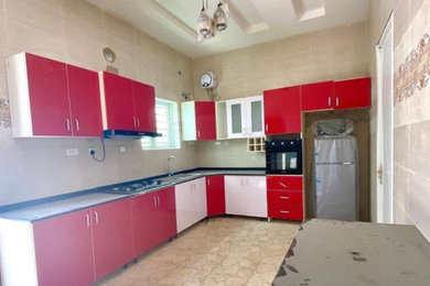 Enclosed kitchen - southwestern l-shaped ceramic tile and wood ceiling enclosed kitchen idea in Other with glass-front cabinets, red cabinets, granite countertops, an island and black countertops