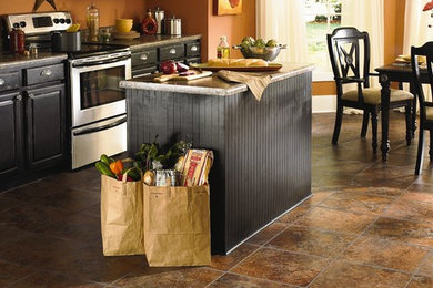 Example of a small southwest single-wall vinyl floor and multicolored floor eat-in kitchen design in Boston with an undermount sink, recessed-panel cabinets, black cabinets, granite countertops and stainless steel appliances