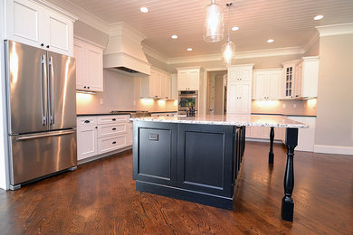 Eat-in kitchen - mid-sized transitional l-shaped dark wood floor and brown floor eat-in kitchen idea in Atlanta with a farmhouse sink, shaker cabinets, white cabinets, granite countertops, stainless steel appliances, an island and black countertops